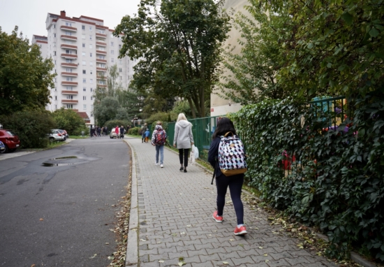 Dzieci idące chodnikiem do szkoły.