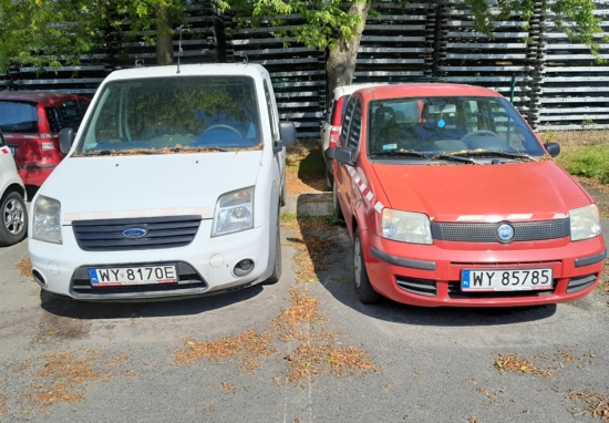 Biały ford i czerwony fiat, wysłużone samochody służbowe ZDM