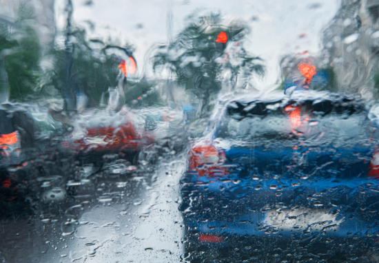 Widok na samochody przez szybę podczas deszczu.
