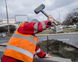 Robotnik w trakcie uderzenia młotkiem.