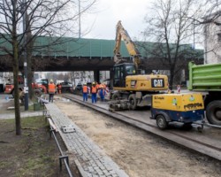 Robotnicy rozprowadzają masę bitumiczną.