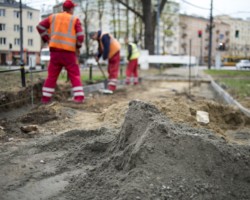 Robotnicy układają krawężnik na pl. Narutowicza.