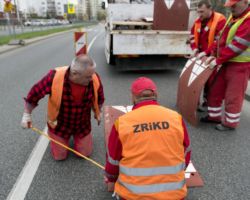 Robotnicy montują progi zwalniające progi na ulicy Umińskiego.