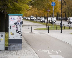 Nielegalny plakat wyborczy naklejony na szafę sterującą sygnalizacją.