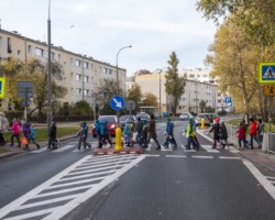 Dzieci przechodzą parami przez przejście dla pieszych na ul. Olbrachta.