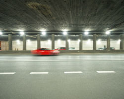 Samochód przejeżdżający oświetlonym tunelem.