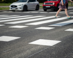 Kobieta przechodząca przez zebrę.