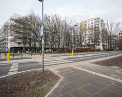 Na zdjęciu widać chodnik, przejście dla pieszych przez ulicę Kłobucką oraz bloki mieszkalne