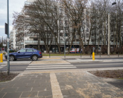 Na zdjęciu widać chodnik. przejście dla pieszych i przejeżdżający po nim samochód osobowy