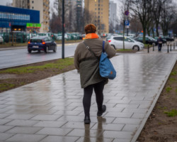 Na zdjęciu widać idącą wyremontowanym chodnikiem kobietę