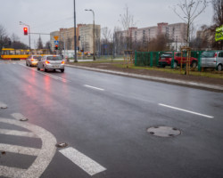 Na zdjęciu widać odnowioną jezdnię, skrzyżowanie, samochody, tramwaj i bloki mieszkalne