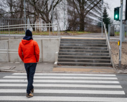 Mężczyzna w czerwonej kurtce przechodzący przez zebrę na ul. Krasińskiego