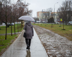 Spacerująca kobieta z parasolką.
