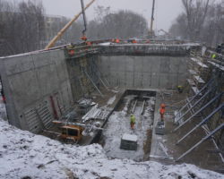 Robotnicy wykonują prace betonowe związane z budową wiaduktu na Marywilskiej podczas opadów śniegu