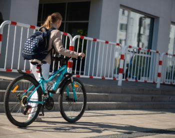 Dziecko prowadzące rower do szkoły