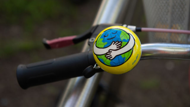 Dzwonek rowerowy z rysunkową ziemią obejmującą samą siebie