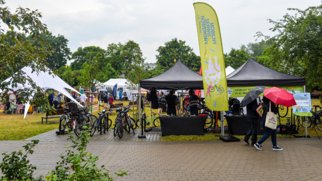 Uczestnicy pikniku przechadzający się obok namiotów Mobilnego Serwisu Rowerowego