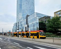 Wschodnia jezdnia pl. Bankowego z nowym asfaltem, przejeżdżający tramwaj i budynki